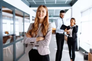 Woman smiling in business apparel with arms crossed in an office